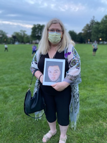 RN Kathy Moreland holding a photo of her late son Austin Layte during a 2021 International Overdose Awareness Day event.