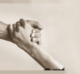 Hands connected as one person lifts up another