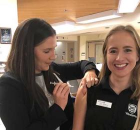 RNAO president-elect Morgan Hoffarth (left) gives the flu shot to Western student Julia Teasdale. This photo was used during  the annual flu campaign on RNAO.ca as well as the association’s social media platforms. RNAO encourages everyone to protect themselves during flu season. 